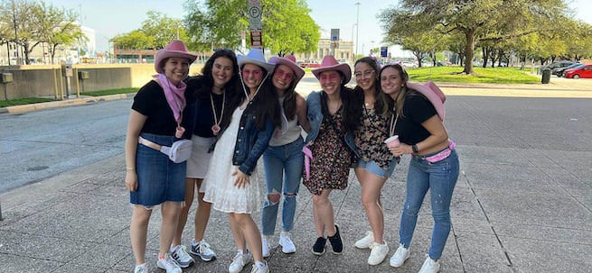 Bachelorette group dressed in cowgirl party outfits during a scavenger hunt