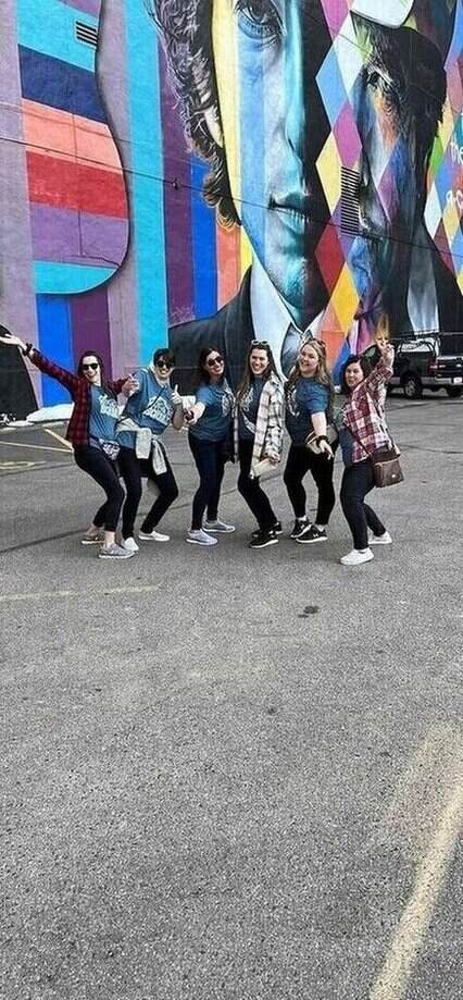 Bachelorette party jumping together during an outdoor city challenge